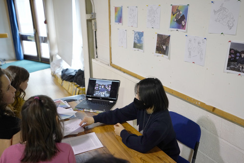 Pupils exhibit portfolios in exam hall.