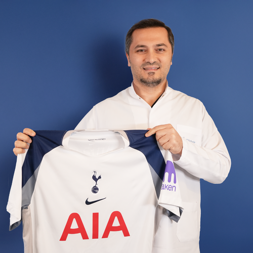 Elithair Dr Balwi holds Tottenham shirt