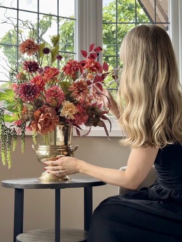 A homeowner styling artificial flowers
